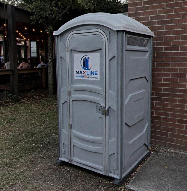 Deluxe flushing portable toilet placed beside a restaurant patio