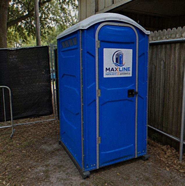 Standard Maxline portable toilet delivered and set on level ground behind a fence